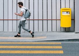 Joven caminando cerca a un paso de cebra