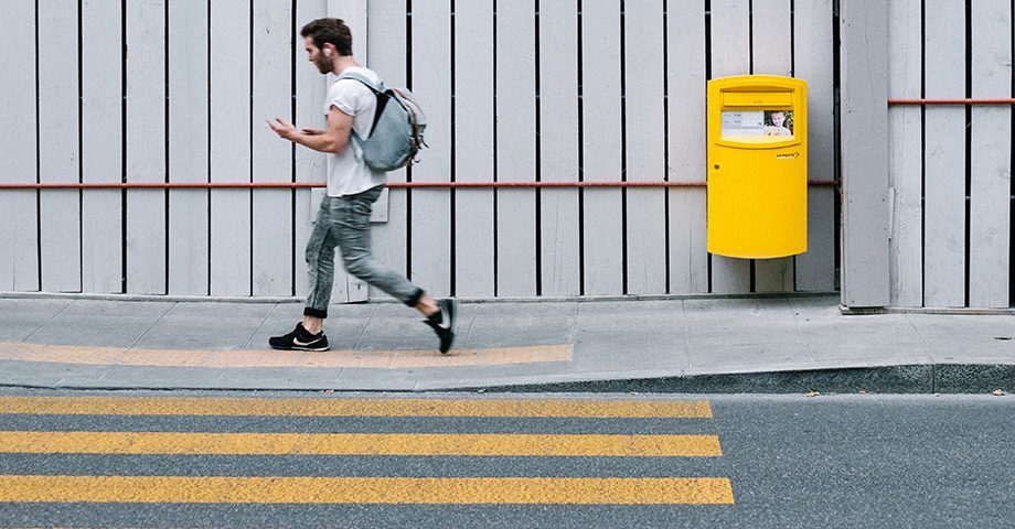 Joven caminando cerca a un paso de cebra