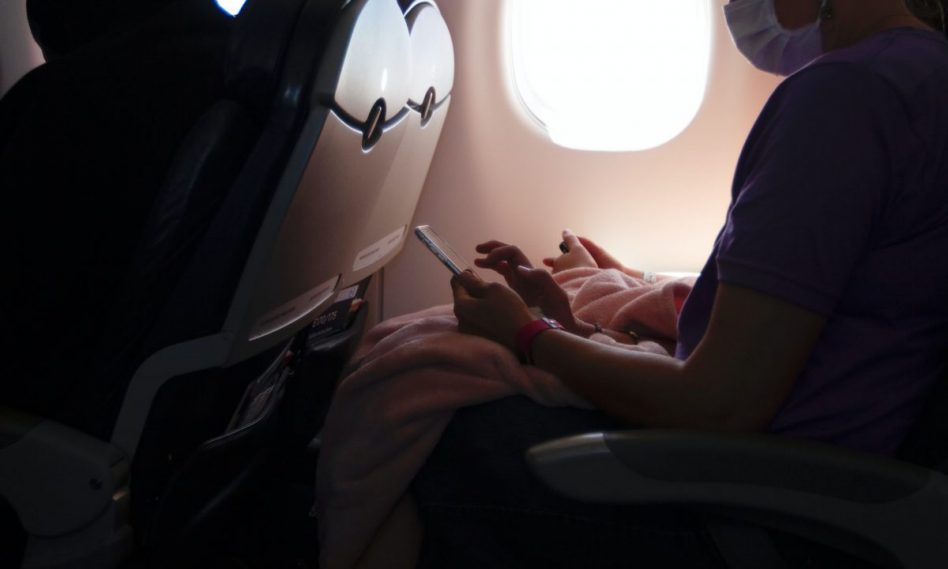 Woman wearing a face mask inside an airplane