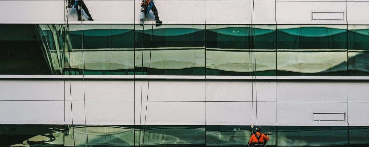 Trabajadores limpiando cristales en altura