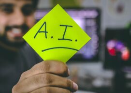 A person holding a post-it note with AI written on it